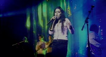 Movie still from “Amy” (2015), directed by Asif Kapadia – A woman singing into a microphone on a stage; Medium shot, Low angle