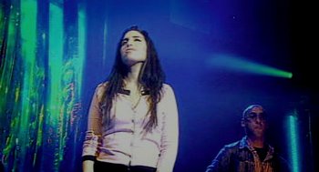 Movie still from “Amy” (2015), directed by Asif Kapadia – A woman standing on a stage in front of a microphone; Medium shot, Low angle