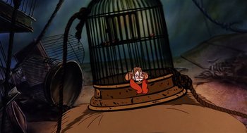 Movie still from “An American Tail” (1986), directed by Don Bluth – A cartoon of a clown sitting in front of a bird cage; Wide shot, High angle