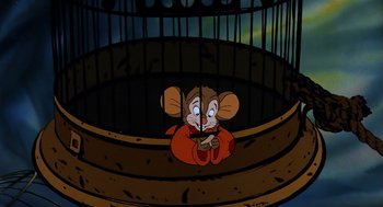 Movie still from “An American Tail” (1986), directed by Don Bluth – A cartoon mouse sitting in front of a bird cage; Medium shot, High angle