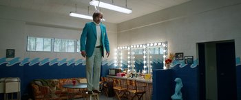 Movie still from “Anchorman 2: The Legend Continues” (2013), directed by Adam McKay – A man standing on top of a stool in front of a mirror; Wide shot, Low angle