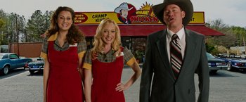 Movie still from “Anchorman 2: The Legend Continues” (2013), directed by Adam McKay – A group of people standing next to each other in front of a store; Medium shot, Low angle