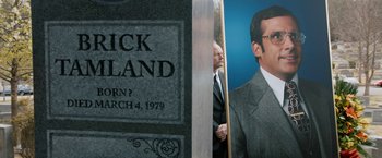 Movie still from “Anchorman 2: The Legend Continues” (2013), directed by Adam McKay – Two men standing next to each other in front of a tombstone; Close Up shot, High angle
