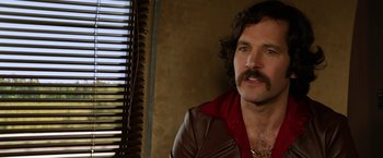 Movie still from “Anchorman 2: The Legend Continues” (2013), directed by Adam McKay – A person wearing a jacket; Close Up shot, Over the shoulder angle