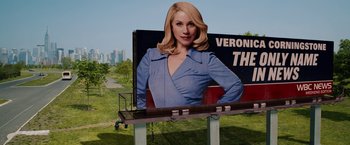 Movie still from “Anchorman 2: The Legend Continues” (2013), directed by Adam McKay – A billboard with a woman's face on top of it; Medium shot, Low angle