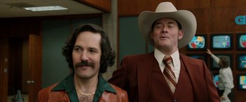 Movie still from “Anchorman 2: The Legend Continues” (2013), directed by Adam McKay – A man in a cowboy hat standing next to another man in a cowboy hat; Medium shot, Low angle