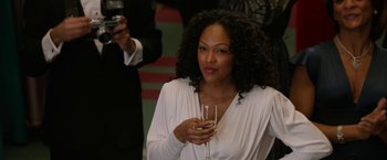 Movie still from “Anchorman 2: The Legend Continues” (2013), directed by Adam McKay – A woman holding a wine glass in her hand; Close Up shot, Over the shoulder angle