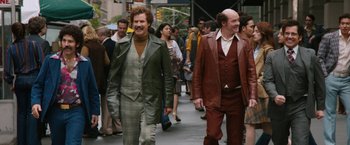 Movie still from “Anchorman 2: The Legend Continues” (2013), directed by Adam McKay – A couple of men walking down a sidewalk; Wide shot, Over the shoulder angle