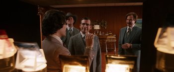 Movie still from “Anchorman 2: The Legend Continues” (2013), directed by Adam McKay – A group of men in suits and hats in a room; Medium shot, Over the shoulder angle