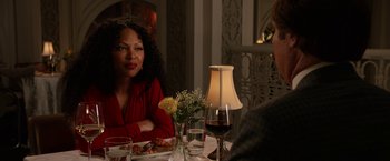 Movie still from “Anchorman 2: The Legend Continues” (2013), directed by Adam McKay – A woman sitting at a table with a glass of red wine; Close Up shot, Over the shoulder angle