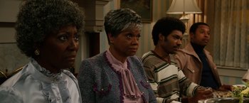 Movie still from “Anchorman 2: The Legend Continues” (2013), directed by Adam McKay – Three people are standing in a room and one of them is wearing a jacket; Close Up shot, Over the shoulder angle