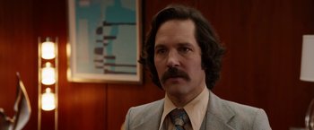 Movie still from “Anchorman 2: The Legend Continues” (2013), directed by Adam McKay – A person wearing a suit and tie; Close Up shot, Over the shoulder angle