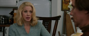 Movie still from “Anchorman 2: The Legend Continues” (2013), directed by Adam McKay – A woman sitting in a chair in front of a wooden chair; Close Up shot, Over the shoulder angle