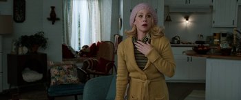 Movie still from “Anchorman 2: The Legend Continues” (2013), directed by Adam McKay – A woman in a pink hat and a yellow sweater; Medium shot, Over the shoulder angle