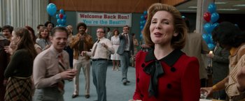 Movie still from “Anchorman 2: The Legend Continues” (2013), directed by Adam McKay – A group of people standing in front of a welcome back ron sign; Medium shot, Over the shoulder angle
