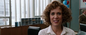 Movie still from “Anchorman 2: The Legend Continues” (2013), directed by Adam McKay – A person sitting at a desk; Close Up shot, Over the shoulder angle