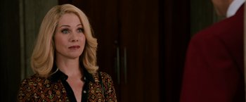 Movie still from “Anchorman 2: The Legend Continues” (2013), directed by Adam McKay – A woman with blonde hair is standing in front of a wall; Close Up shot, Over the shoulder angle