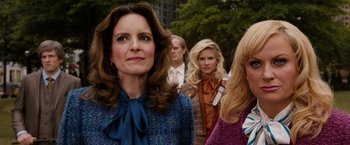 Movie still from “Anchorman 2: The Legend Continues” (2013), directed by Adam McKay – A group of people standing next to each other; Medium shot, Over the shoulder angle