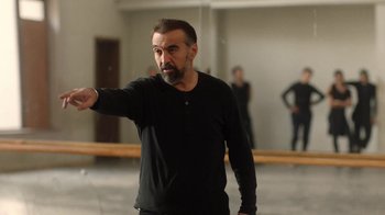 Movie still from “And Then We Danced” (2019), directed by Levan Akin – A man in a black shirt is pointing at something; Medium shot, Over the shoulder angle