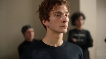 Movie still from “And Then We Danced” (2019), directed by Levan Akin – A young man in a black shirt is looking at the camera; Close Up shot, Low angle