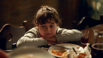 Movie still from “And Then We Danced” (2019), directed by Levan Akin – A little girl sitting at a table in front of a plate of food; Close Up shot, High angle