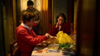 Movie still from “And Then We Danced” (2019), directed by Levan Akin – Three people sitting at a table with food on it; Medium shot, Over the shoulder angle
