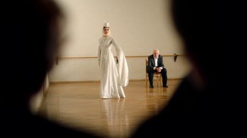 Movie still from “And Then We Danced” (2019), directed by Levan Akin – A man and a woman dressed in medieval garb in an indoor setting; Wide shot, Over the shoulder angle