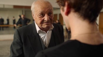 Movie still from “And Then We Danced” (2019), directed by Levan Akin – An older man looking at a young man in a suit; Close Up shot, Over the shoulder angle