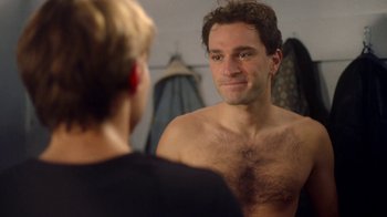 Movie still from “And Then We Danced” (2019), directed by Levan Akin – A man looking into a mirror while standing next to a woman; Close Up shot, Over the shoulder angle
