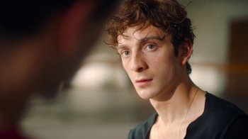 Movie still from “And Then We Danced” (2019), directed by Levan Akin – A person wearing a black shirt; Close Up shot, Over the shoulder angle