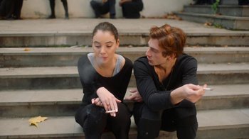 Movie still from “And Then We Danced” (2019), directed by Levan Akin – A man and a woman sitting on some steps smoking; Medium shot, Over the shoulder angle