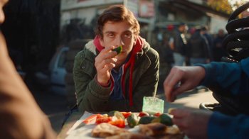 Movie still from “And Then We Danced” (2019), directed by Levan Akin – A man sitting at an outdoor table eating a piece of food; Close Up shot, Over the shoulder angle