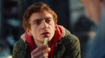 Movie still from “And Then We Danced” (2019), directed by Levan Akin – A young man holding a piece of food in his hand; Close Up shot, Over the shoulder angle