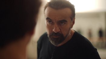 Movie still from “And Then We Danced” (2019), directed by Levan Akin – A man stares into a mirror while wearing a black shirt; Close Up shot, Over the shoulder angle