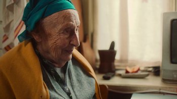 Movie still from “And Then We Danced” (2019), directed by Levan Akin – An old woman sitting at a table in a room; Close Up shot, Over the shoulder angle