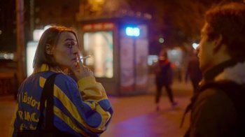 Movie still from “And Then We Danced” (2019), directed by Levan Akin – A woman smoking a cigarette while standing on the street; Medium shot, Over the shoulder angle
