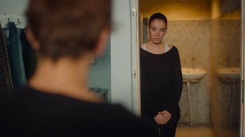 Movie still from “And Then We Danced” (2019), directed by Levan Akin – A woman standing in front of a mirror in a room; Medium shot, Over the shoulder angle