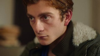 Movie still from “And Then We Danced” (2019), directed by Levan Akin – A person wearing a jacket; Close Up shot, Low angle