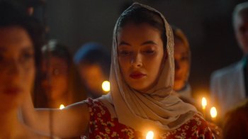Movie still from “And Then We Danced” (2019), directed by Levan Akin – A woman with a head scarf is holding a candle; Close Up shot, Low angle