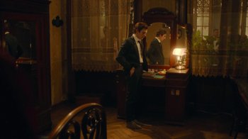 Movie still from “And Then We Danced” (2019), directed by Levan Akin – A man standing in front of a mirror in a room; Wide shot, High angle