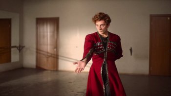 Movie still from “And Then We Danced” (2019), directed by Levan Akin – A man in a red coat holding something in his hand; Medium shot, Low angle