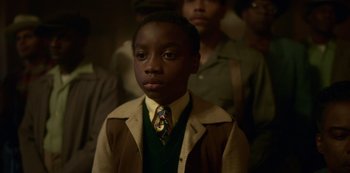 Movie still from “Fargo” (2014), created by Noah Hawley – A young boy wearing a suit and a tie; Close Up shot, High angle