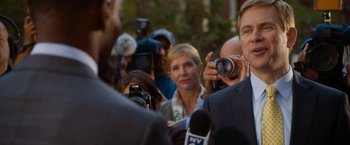 Movie still from “Annie” (2014), directed by Will Gluck – A man taking a picture of a crowd of people with a camera; Medium shot, Over the shoulder angle