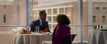 Movie still from “Annie” (2014), directed by Will Gluck – A man and a woman are sitting at a table; Medium shot, Over the shoulder angle