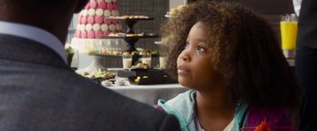 Movie still from “Annie” (2014), directed by Will Gluck – A young girl sitting in front of a table of desserts; Close Up shot, Over the shoulder angle