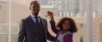 Movie still from “Annie” (2014), directed by Will Gluck – A man and a young girl holding up a crab; Medium shot, Over the shoulder angle