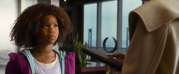 Movie still from “Annie” (2014), directed by Will Gluck – A young girl is looking at a person holding a tablet; Close Up shot, Over the shoulder angle