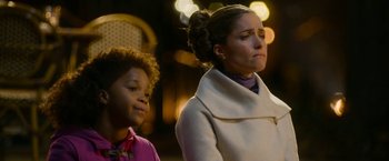 Movie still from “Annie” (2014), directed by Will Gluck – A woman and a child standing next to each other on a street; Close Up shot, Over the shoulder angle
