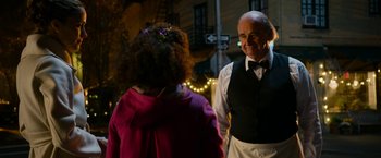 Movie still from “Annie” (2014), directed by Will Gluck – An older man and a little girl standing next to each other on the street; Medium shot, Over the shoulder angle