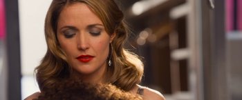 Movie still from “Annie” (2014), directed by Will Gluck – A woman with red lipstick is looking down at her face; Close Up shot, Over the shoulder angle
